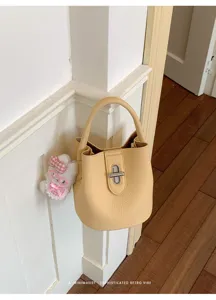 Vue détaillée du sac seau jaune élégant montrant sa texture raffinée et son joli pendentif.