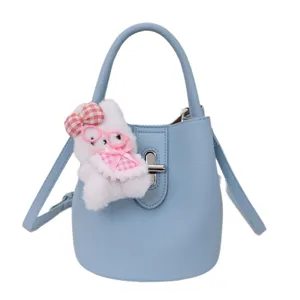 Sac seau bleu clair élégant pour femme avec un joli pendentif de lapin en peluche douce.