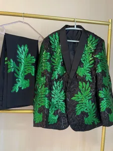 Conjunto de traje negro para hombre con bordado de hojas verdes y pantalones a juego.
