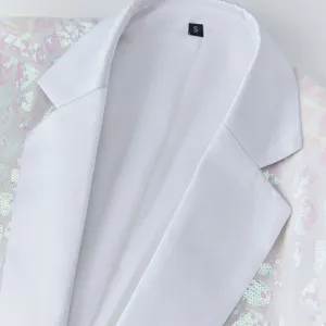 Close-up detail of white sequin blazer collar and fabric texture, perfect for evening parties.