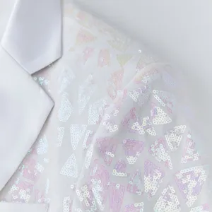 Close-up detail of white men's sequin blazer featuring colorful geometric triangle sequins.