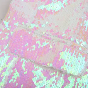 Close-up of iridescent pink sequin fabric detail, sparkling texture for stage wear jacket.