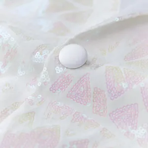 Close-up detail of white men's sequin suit fabric featuring pink geometric triangle pattern.