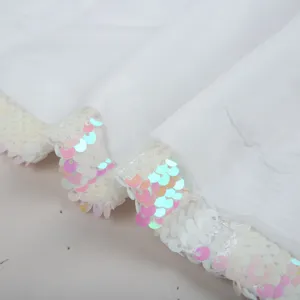 Close-up detail shot of white fabric with sparkling multi-color reversible sequins.
