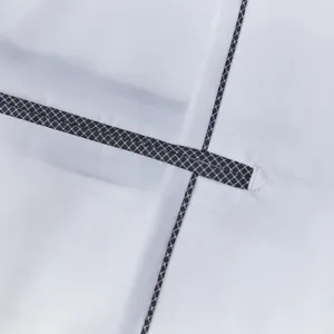Detailed close-up shot of men's suit jacket seam and black white grid trim craftsmanship.
