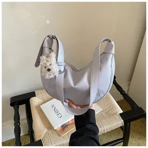 Borsa casual grigia a mezzaluna con ciondolo cucciolo in peluche per donne.