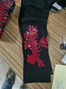 Vista detallada de tela negra con intrincado diseño de apliques de bordado de lentejuelas.