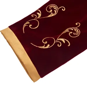 Detailed view of men's burgundy velvet suit jacket sleeve with exquisite gold palace embroidery.