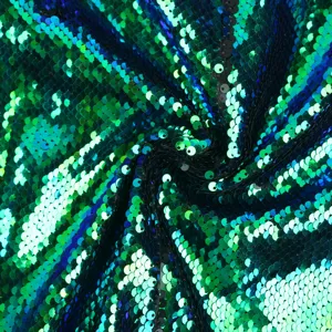 Close-up detail of vibrant green and blue flip sequins fabric, sparkling texture for stage garments.