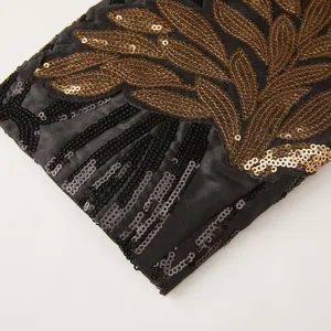 Men's gold sequin applique suit jacket detail, black fabric with embroidered sparkling patterns.
