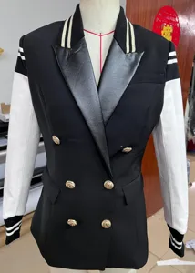 Detailed view of women's black and white contrast colorblock blazer with gold buttons.