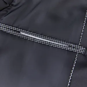 Detailed close-up view of men's jacket fabric featuring a stylish reflective stripe and grid trim.