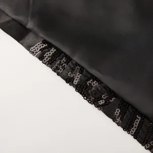Close-up detail of black suit jacket with stylish sequin trim, premium fabric texture.