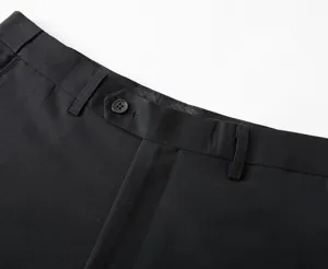 Detalle de cintura de pantalón de traje negro, confección profesional con costuras finas.