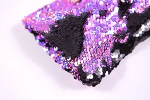 Close-up detail of purple and black reversible sequin fabric for glamorous stage costume apparel.