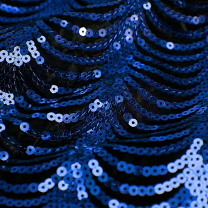 Detailaufnahme einer blauen Pailletten-Jungenjacke mit glitzerndem Wellenmuster Stoff.