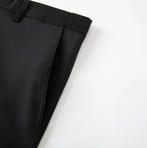 Detalle de pantalon de traje negro para hombre con acabados finos en bolsillos y cintura.