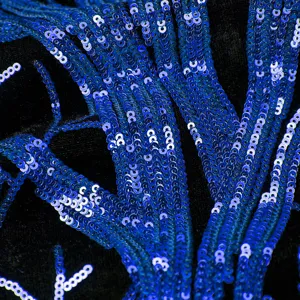 Λεπτομερές κοντινό πλάνο μπλε κεντήματος με πούλιες σε μαύρο ύφασμα για σακάκι.