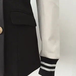 Color-block black and white blazer jacket with ribbed striped cuffs and gold buttons.