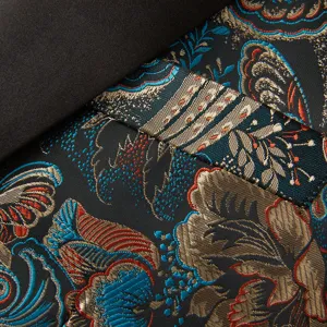 Gros plan sur le tissu de costume jacquard pour hommes avec des motifs floraux dorés.