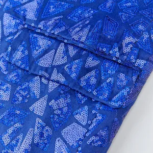 Close-up detail of men's blue sequin blazer featuring geometric triangle pattern design.