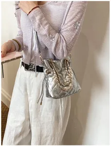 Silver quilted chain shoulder bag, stylish bucket design with metallic hardware for women.