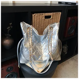 Silver metallic quilted tote bag with gold chain straps, luxurious style detail view.