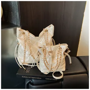 Detailed view of fashionable quilted tote bags with metal chain straps and chic design.