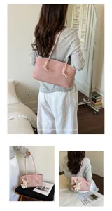 Minimalist pink tote bag for women, stylish shoulder handbag with cute bear pendant and commuting design.