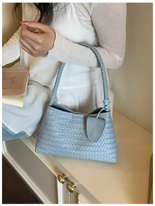 Detailed view of the stylish woven shoulder bag, featuring premium blue leather and chic design.