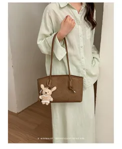 Minimalist brown tote bag with cute knitted bunny charm, perfect for daily commuting style.