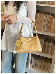 Detailed shot of yellow woven leather shoulder bag showcasing intricate texture and elegant style.