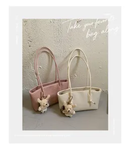 Detailed view of the stylish large capacity tote shoulder bag with cute knit bear keychain.