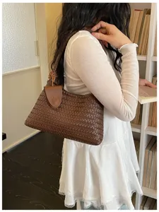 Detail shot of the trendy brown woven shoulder bag featuring a chic classic pattern style.