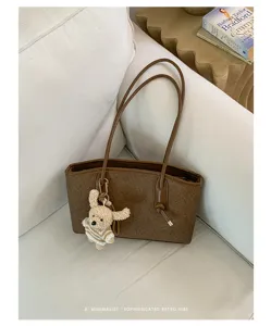 Stylish large capacity brown tote bag with cute bear pendant for women commuter daily use.