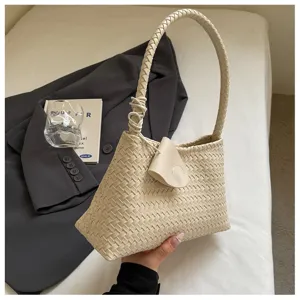 Beige woven shoulder bag, elegant underarm bag style with braided handle for women.