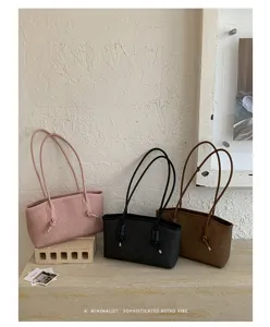 Minimalist retro shoulder bag with slim straps and knot detail, stylish commuter tote.