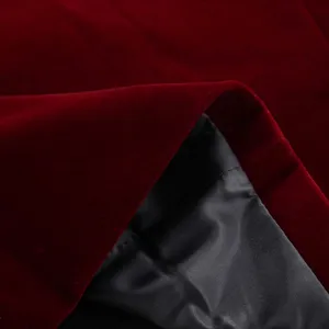 Burgundy velvet suit jacket fabric detail showing rich texture and black lining interior.