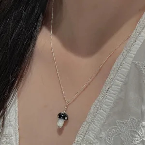 Detalle del collar de plata S925 con colgante de seta en blanco y negro estilo retro.