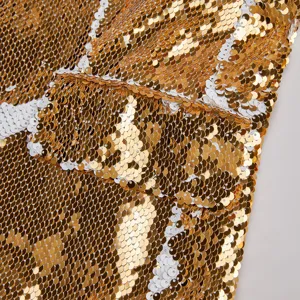 Primer plano de la textura de tela con lentejuelas doradas y blancas bicolor.