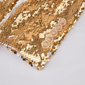 Detalle de primer plano de la manga de un blazer de lentejuelas doradas brillantes.