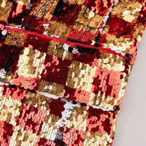 Primer plano detallado de la textura de tela de lentejuelas reversibles rojas y doradas.