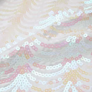 Nahaufnahme von glitzerndem Wellen-Paillettenstoff mit schimmerndem rosa und weißem Finish.