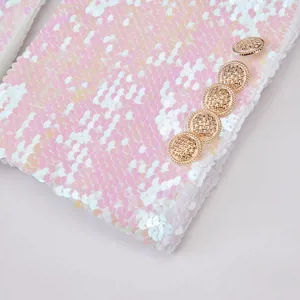 Primer plano de los detalles de la chaqueta de lentejuelas con lentejuelas rosas y botones dorados.