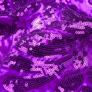 Close-up detail shot of purple sequin fabric, shimmering texture for fashion apparel.