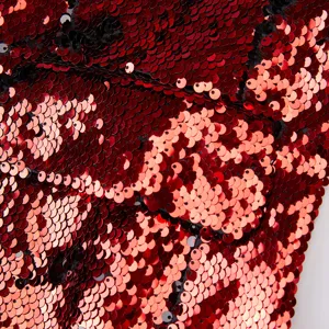 Detalle en primer plano de lentejuelas reversibles rojas y negras con textura brillante para blazer.