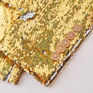 Primer plano del puño de blazer de lentejuelas de mujer, con lentejuelas doradas y botones metálicos.