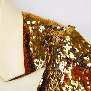 Impresionante detalle de blazer de lentejuelas doradas con solapa de raso crema muy elegante.