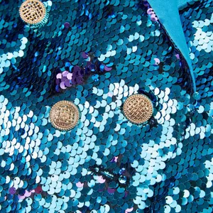 Detalle en primer plano de blazer de mujer de lentejuelas azules con botones dorados.