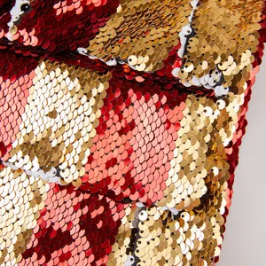 Detalle en primer plano de tela de lentejuelas reversibles roja y dorada para blazers.